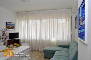 利多迪耶索罗Shopping Center Apartments D08的客厅配有蓝色的沙发和电视