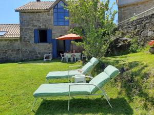 穆罗斯Casa Campo de Cortes的院子里设有三把躺椅和一张桌子