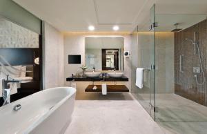 阿布扎比阿布扎比艾尔胡瑟万豪酒店的浴室设有2个水槽、浴缸和镜子