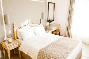 米克诺斯城普里肯酒店的白色卧室配有床和镜子