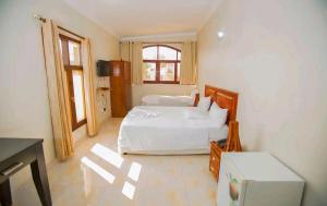马普托Lidia's Place Guest House的卧室配有白色的床和窗户。