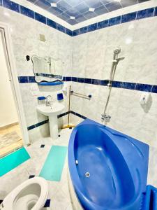 亚历山大Alexandria Luxury Apartments Stanley Direct Sea View的浴室配有蓝色浴缸和水槽