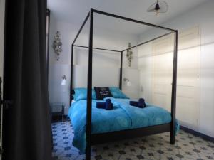 新堡Pool House Renoir mit geheiztem Pool und Privatgarten的一间卧室配有黑色天蓬床和蓝色床单