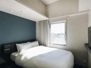 宫崎Prince Smart Inn Miyazaki的卧室配有白色的床和窗户。