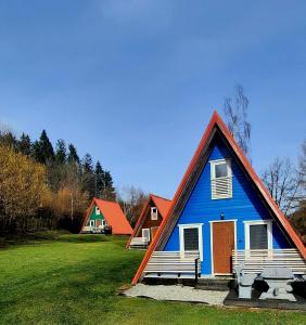 希隆斯克地区扎古热Kolorowe Wzgórze Zagórze的蓝色房子,有两长椅在田野里