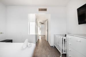 埃拉特LuxuryApt/BestView/PerfectForFamilies/FreeParking的白色卧室设有白色的床和走廊