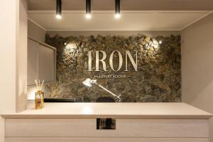 罗马IRON Luxury Rooms的前台设有石墙和铁标