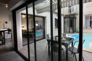 拉罗谢尔Villa Maurice avec piscine centre La Rochelle的客厅设有桌子和游泳池