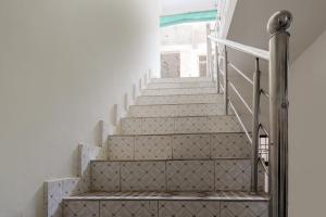 瓜廖尔OYO Siddhi Vinayak Guest House的白色墙壁和白色台阶的房屋内的楼梯