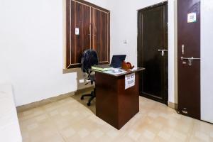 瓜廖尔OYO Siddhi Vinayak Guest House的办公室,办公桌上配有笔记本电脑和门
