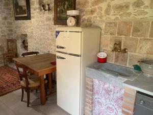 Casa tipica sarda的厨房配有白色冰箱,设有桌子