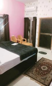 AyodhyaPremshi Guest House的一间卧室配有床、椅子和窗户