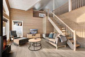 弗罗达尔Moderne hytte met eindeloos uitzicht en een sauna的一间带楼梯和沙发的客厅
