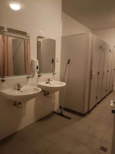 布拉迪斯拉发Ubytovňa Nobelova的浴室设有2个水槽、镜子和摊位。