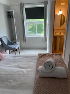 奥斯顿菲尔德Newton House的一间卧室配有一张床,床上有毛巾