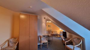 沃尔加斯特Hotel Peenebrücke的客房设有带桌椅的楼梯。