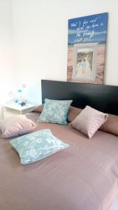 帕拉迪索海岸Villini Cala del Sole - INFINITYHOLIDAYS的床上配有粉红色和蓝色枕头