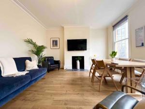 伦敦4 Bed Apartment- Archway Station的客厅配有蓝色的沙发和桌子