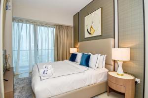 迪拜Sea-View 2Bedroom plus Sofa Bed - Near JBR Beach - HEI的卧室配有带蓝色枕头的大型白色床