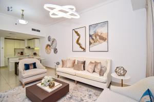 迪拜Sea-View 2Bedroom plus Sofa Bed - Near JBR Beach - HEI的客厅配有沙发、椅子和桌子