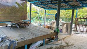 巴西富地Teratak Cikgu Homestay的一个带蓝色屋顶的木甲板的门廊