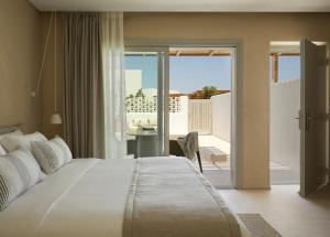 安倍拉斯PAROCKS Luxury Hotel & Spa的一间带一张白色大床的卧室和一个阳台