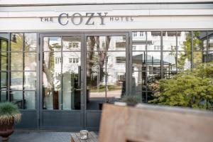 蒂门多弗施特兰德The Cozy Hotel & Lofts Timmendorfer Strand的舒适的酒店的大堂,设有玻璃门