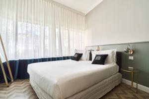 米兰Brera Boutique Suites Milano的一张大床,位于带大窗户的房间里