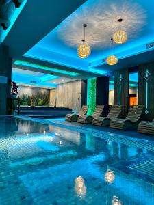 什恰夫尼察Hotel Maria & Spa的游泳池,带椅子和灯