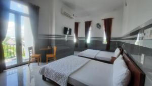 Tràm ChimVIEW HOTEL-TRÀM CHIM的一间卧室设有两张床、一张桌子和一个窗口