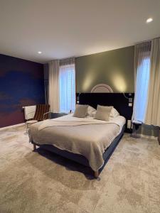 皮耶尔佩尔塞埃Logis Hôtel Altitude et Spa Pierre-Percée的一间卧室设有一张大床和蓝色的墙壁