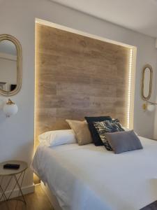 萨拉戈萨La Parada de la Estacion con parking的卧室配有一张白色大床和木制床头板
