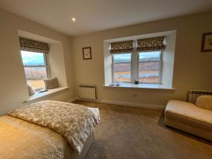 伊文格瑞Tomdoun Estate的一间卧室设有2个窗户和1张床