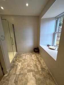 伊文格瑞Tomdoun Estate的带淋浴的浴室和瓷砖地板。