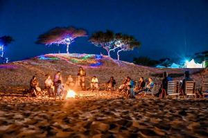 LompoulCamp Rêve de Nomade的一群人晚上在海滩上火堆旁