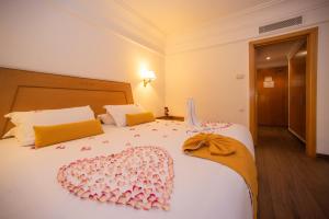 阿加迪尔阿加迪尔提姆雷酒店及Spa的一间卧室配有两张床,拥有粉红色的装饰