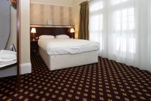 滨海韦斯顿卡伯特苑威瑟斯本酒店的酒店客房设有一张大床和窗户。