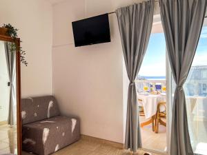 马卡尔斯卡Apartment Holiday Makarska的一间房间,墙上有椅子和电视
