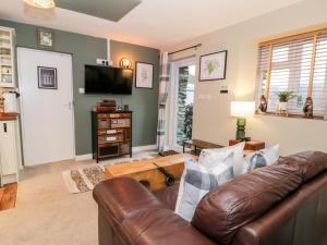 卡纳芬Cwm Caeth Cottage的客厅配有真皮沙发和电视