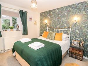 卡纳芬Cwm Caeth Cottage的一间卧室配有带绿色和橙色枕头的床