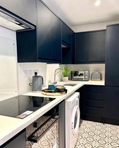 海塞Studios 21- By Eazy Rooms的厨房配有蓝色橱柜和洗衣机。