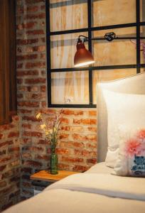 魏玛36 Phô Cô Hotel & Suites的一间卧室配有一张床和一张桌子上的台灯