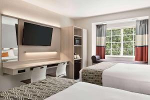 罗利温德姆不伦瑞克省麦克罗套房酒店的酒店客房设有两张床和一台平面电视。