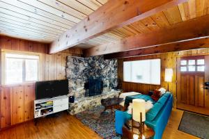 塔霍城Ward Creekside Cabin的客厅设有蓝色的沙发和石制壁炉