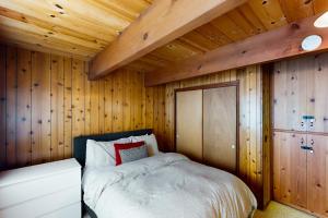 塔霍城Ward Creekside Cabin的卧室配有木墙内的一张床