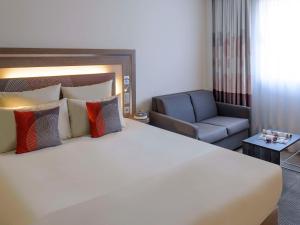 卢加诺诺富特卢加诺天堂酒店 的酒店客房带一张大床和一把椅子