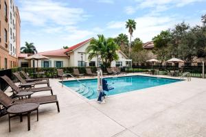 西棕榈滩西棕榈滩希尔顿惠庭套房酒店的一个带躺椅的游泳池,一个度假村