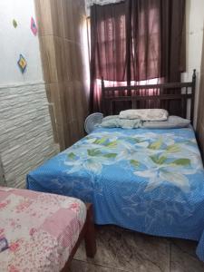 Antônio PradoCasinhas no Interior de MG的一间卧室配有一张带蓝色棉被的床