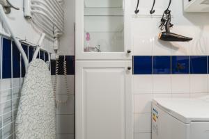 克拉科夫Kawiory 2/22的浴室铺有蓝色和白色瓷砖,配有水槽