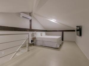 布希奥斯伊利亚布兰卡酒店的白色的客房配有床和电视。